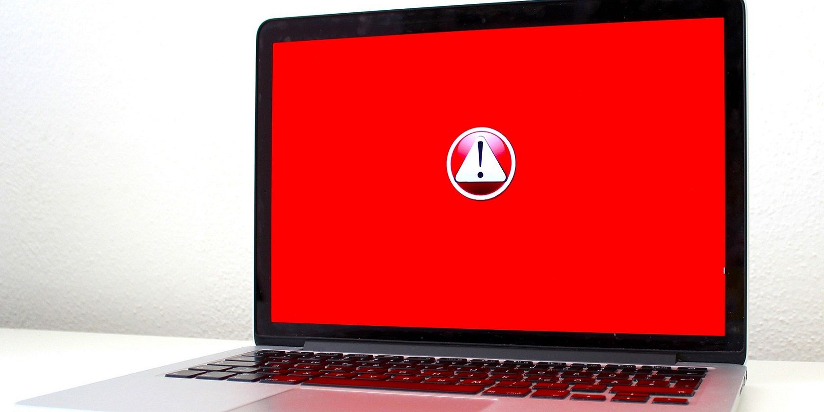 An error exclamation symbol on red laptop