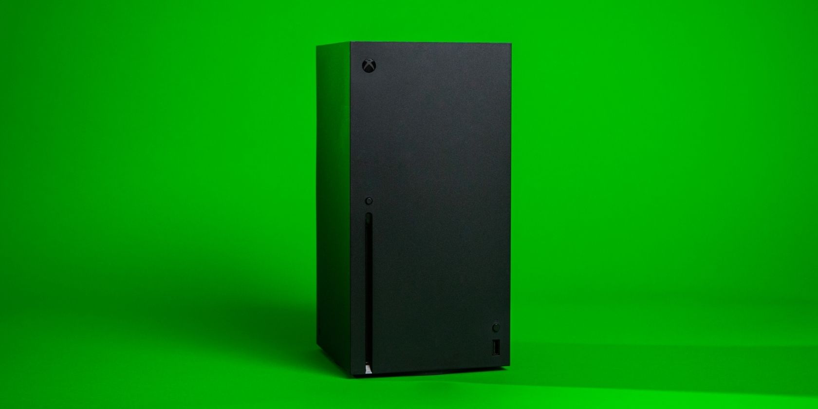 A photograph of an Xbox Series X console in front of a bright green background