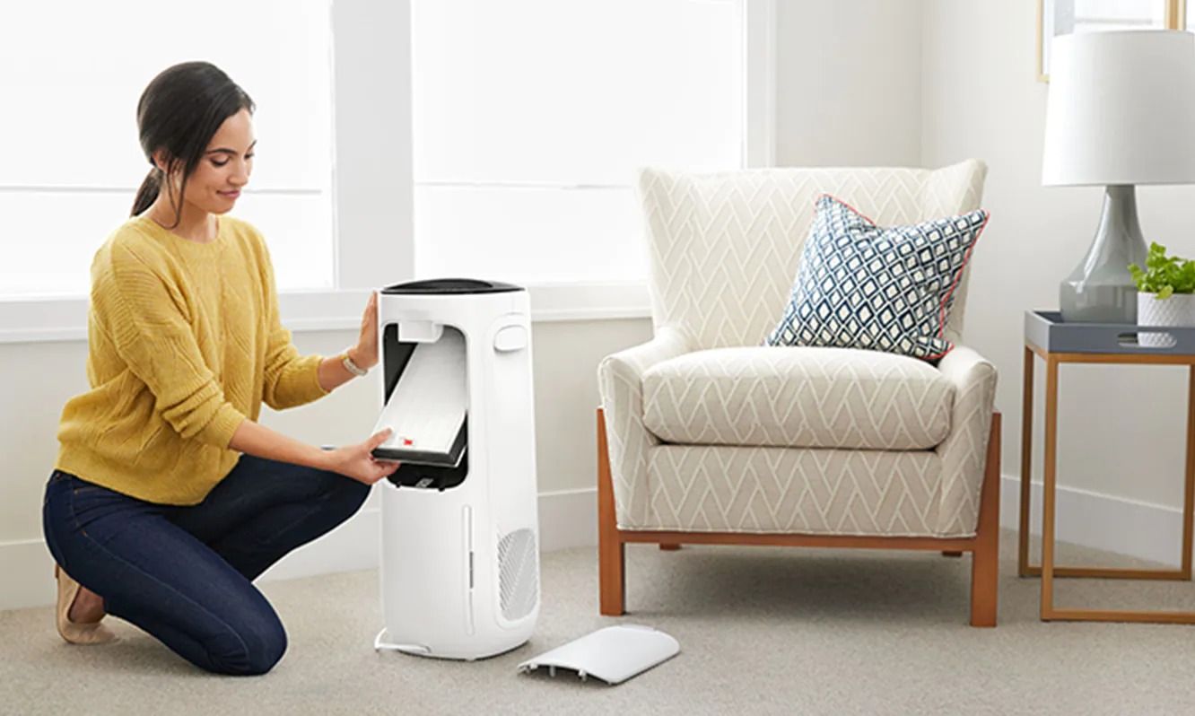 Woman changing filter in air purifier