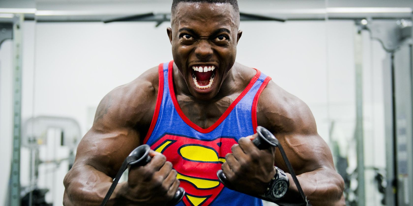 Man lifting weights in a superman shirt