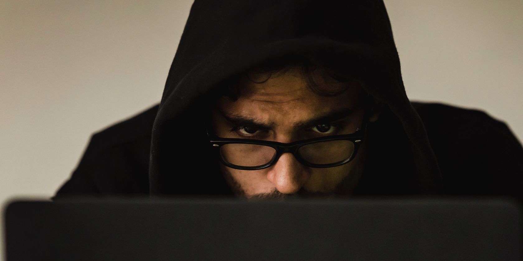 hooded person using laptop