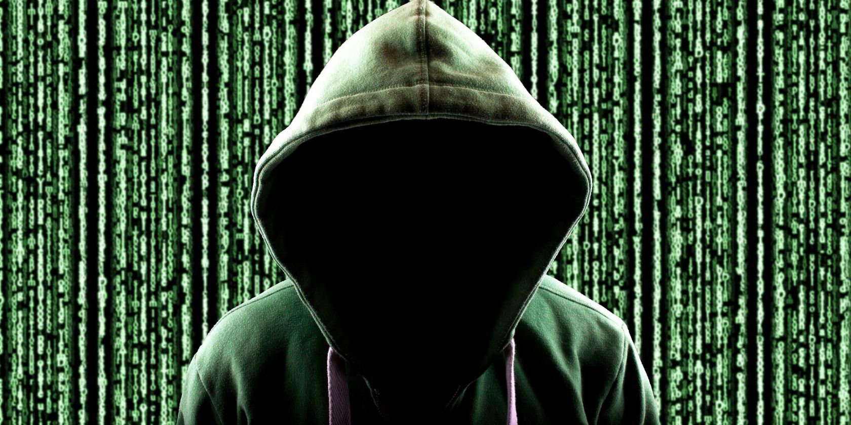 personaje anónimo con capucha frente al código de matriz