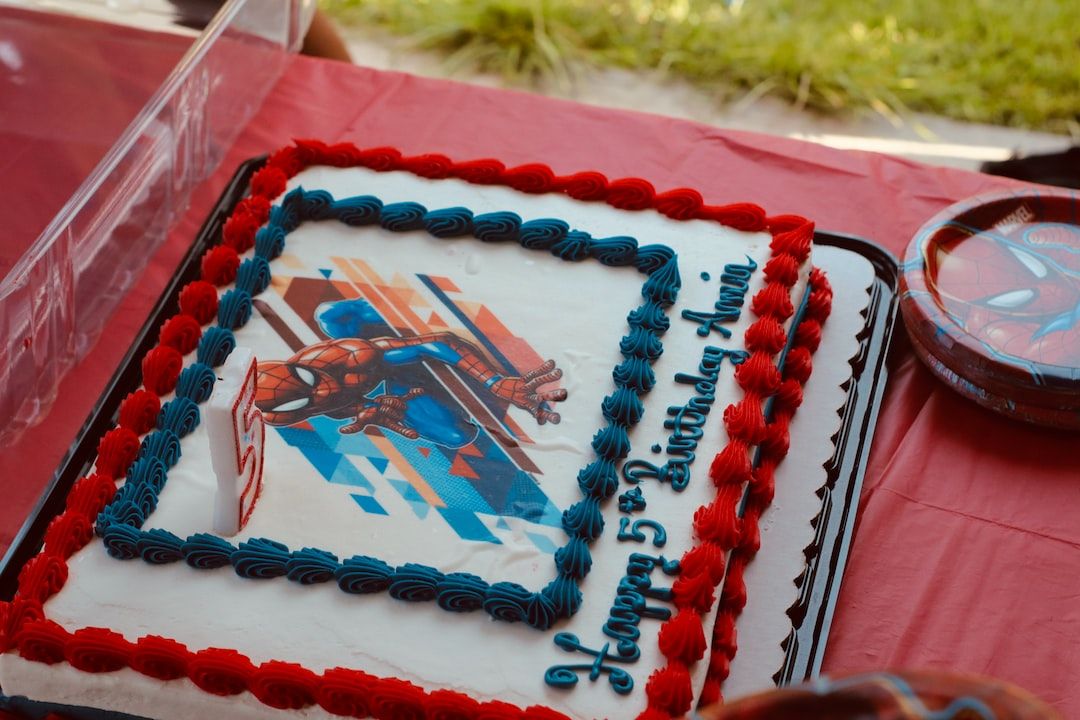 Un gâteau avec une illustration, dans le glaçage, du personnage de Spider-Man au-dessus des mots 