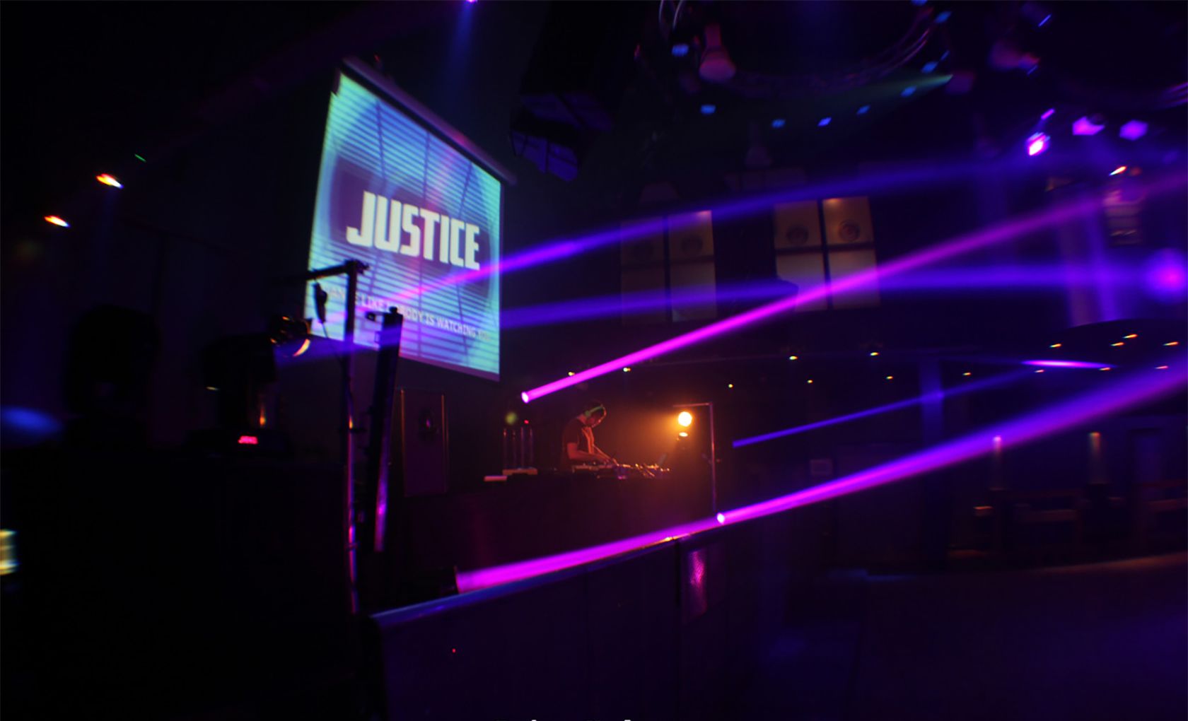 DJ in empty nightclub with collared spotlights illuminating the space.