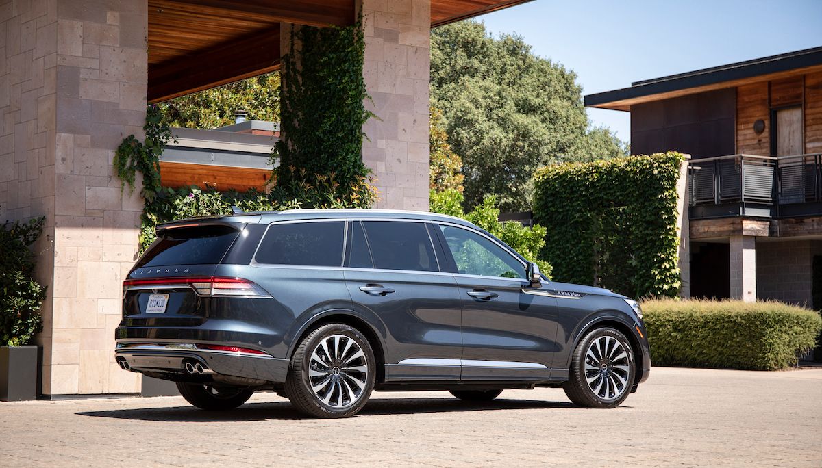 Lincoln Aviator Grand Touring đậu bên ngoài những tòa nhà mộc mạc phủ đầy cây cỏ