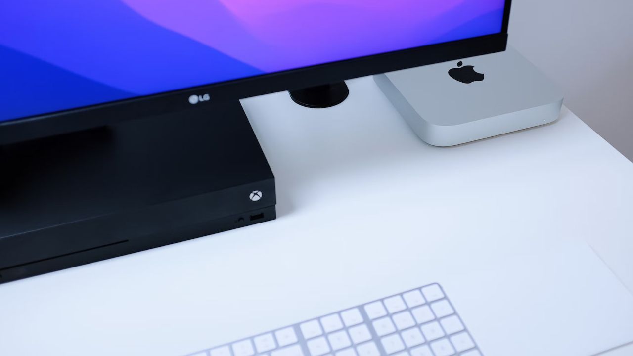 Mac mini next to LG display, Apple keyboard, and trackpad