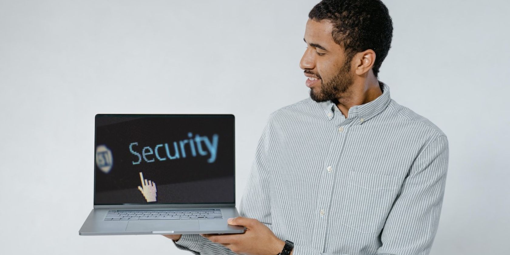 MacBook Pro in a man's hand with the word “Security” on screen