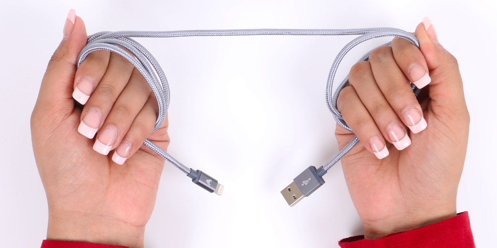 Hands grabbing gray iPhone charging cord