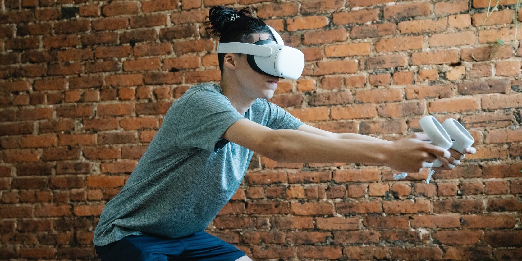 person wearing virtual reality headset and using controls to play VR fitness game