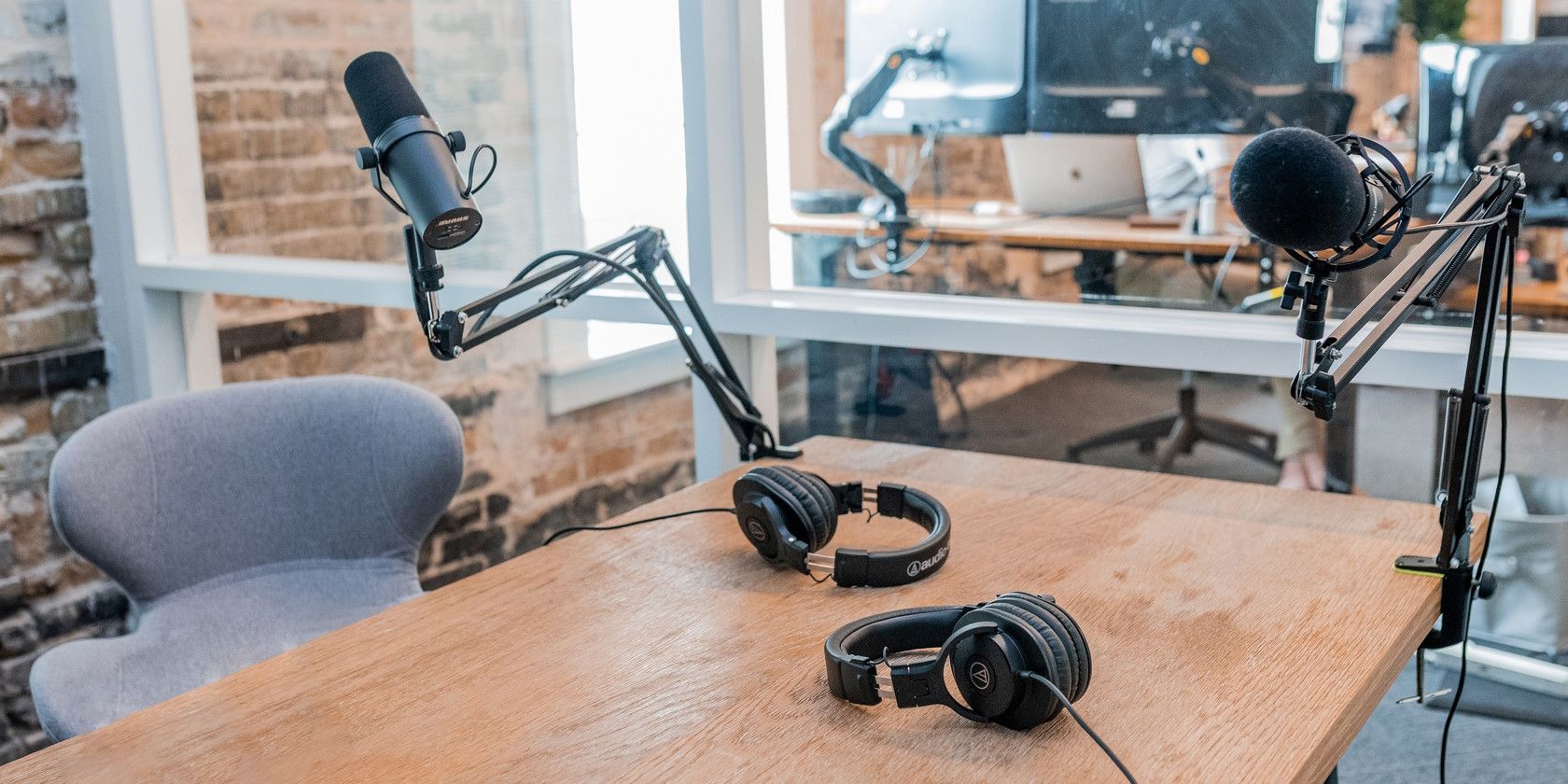 two black microphones headphones on office desk in podcast studio
