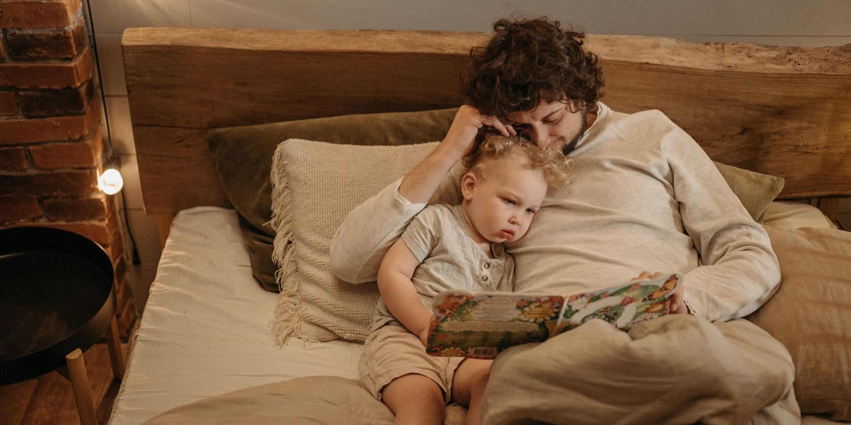 Man and baby lying in bed reading bedtime sleep story
