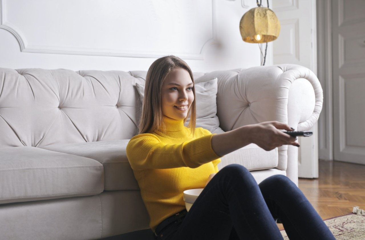 A relaxed young woman watching TV