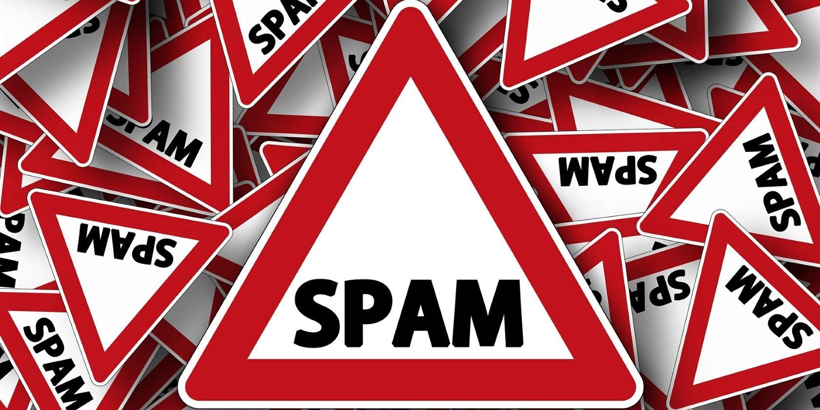 Numerous triangular warning signs displaying the word spam
