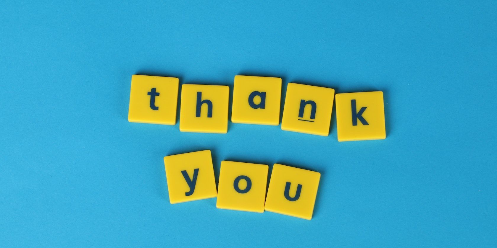 thank you written in yellow tiles and blue background