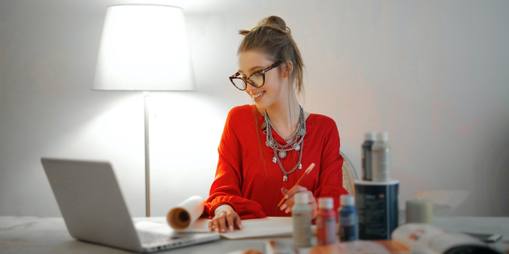 Woman With Red Shirt Smiling on Laptop Sitting On Desk