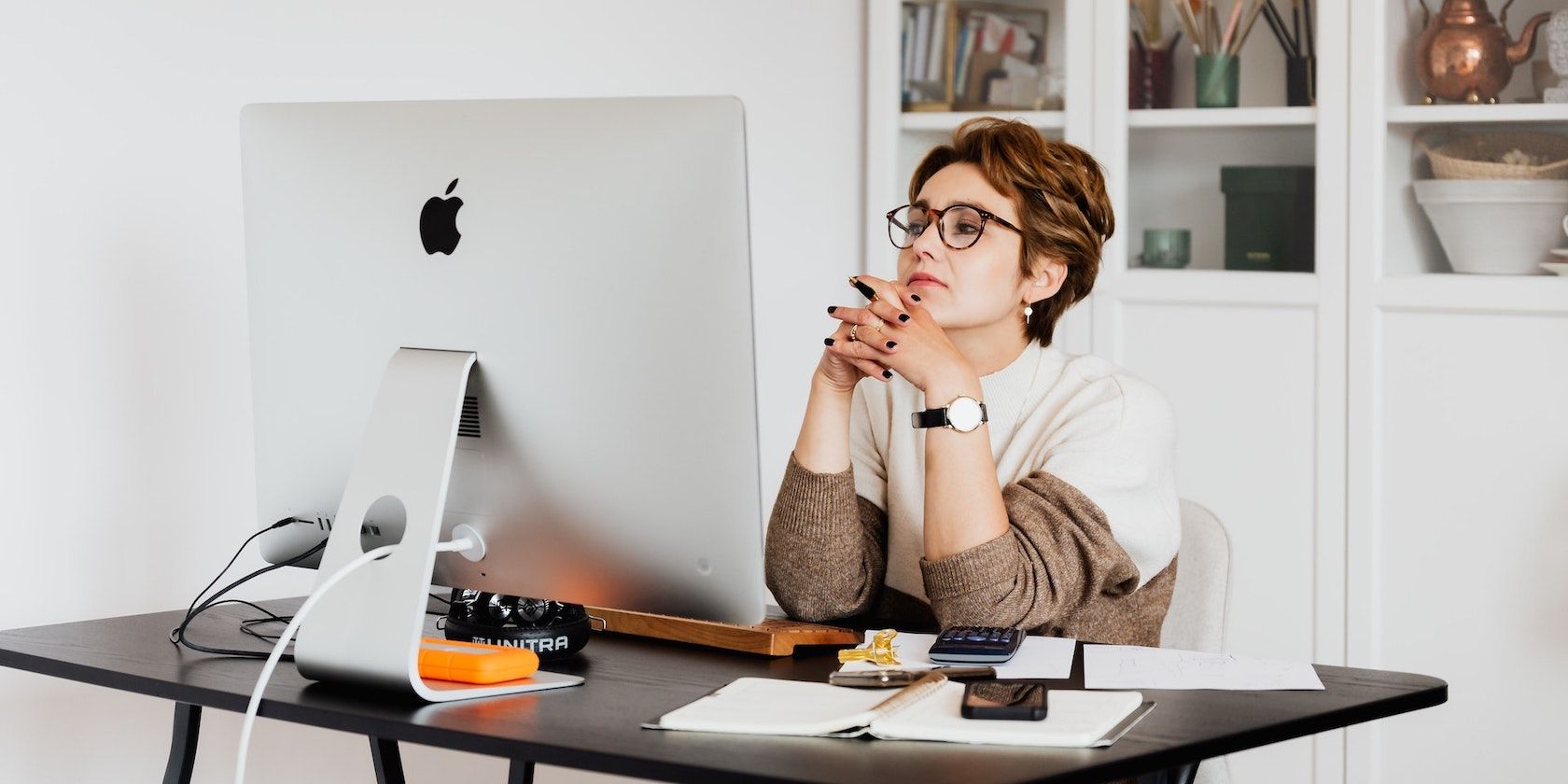 Woman With Glasses Thinking While Using iMac