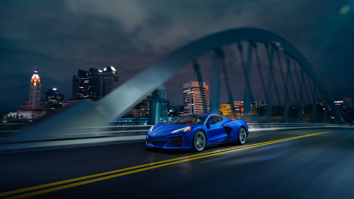 A blue 2024 Corvette E-Ray 3LZ driving on a bridge at night