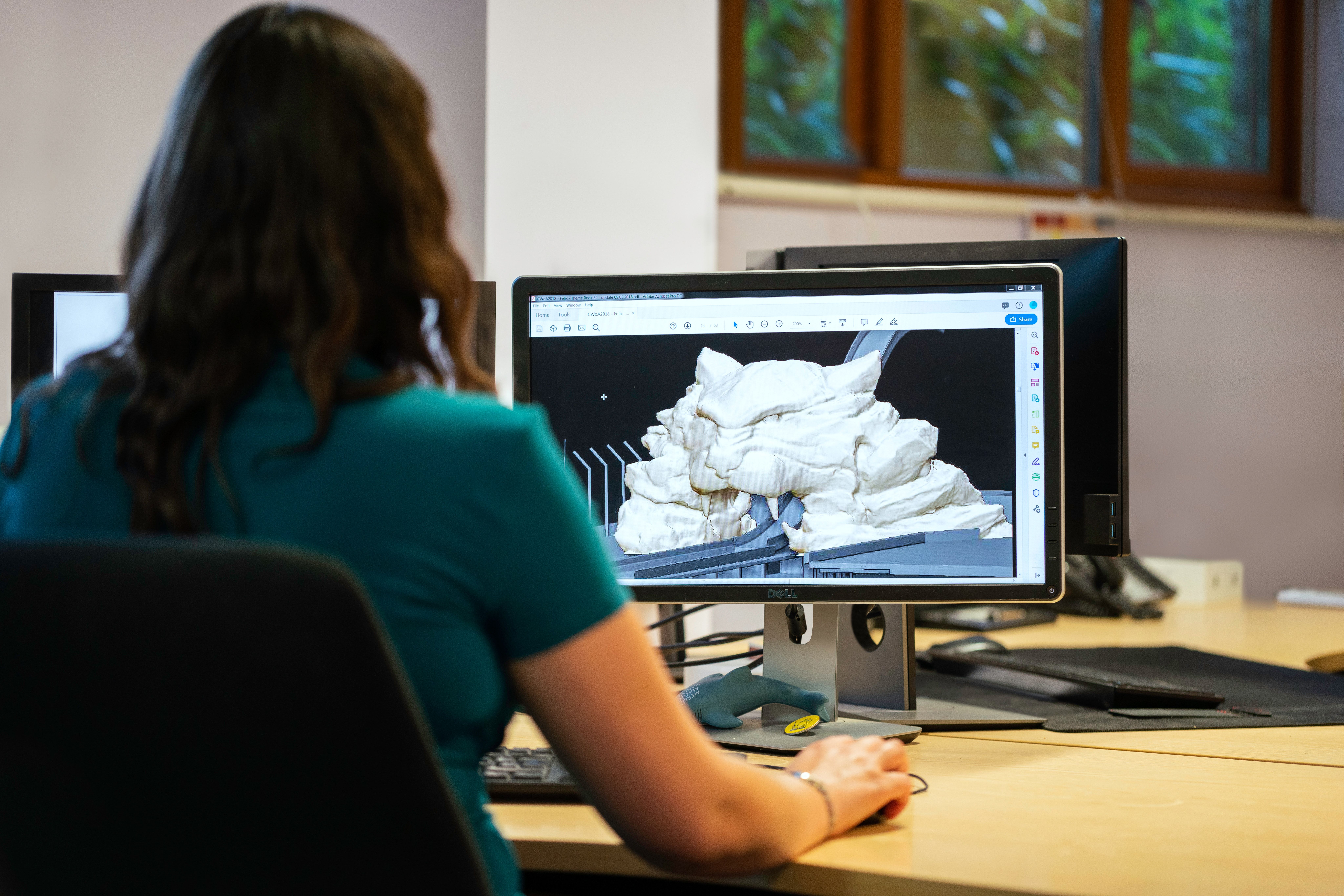 Woman sitting in front of PC designing a 3D model