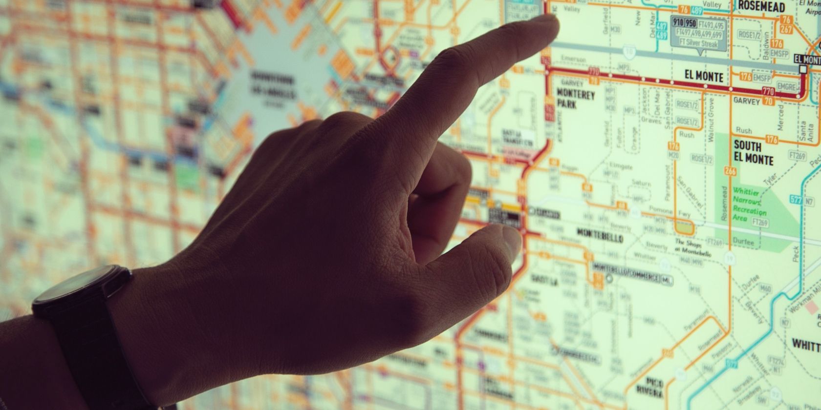 A hand pointing at a digital map on the wall