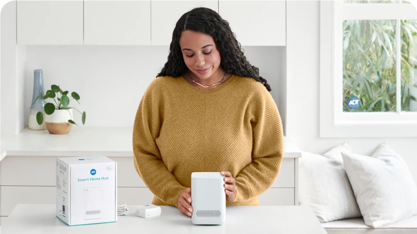 a lady unpackaging the adt smart home hub