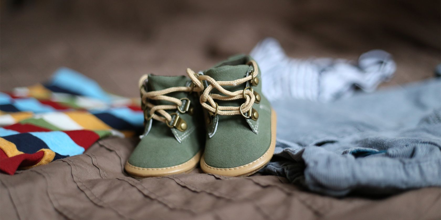 Baby shoes on top of baby clothes.