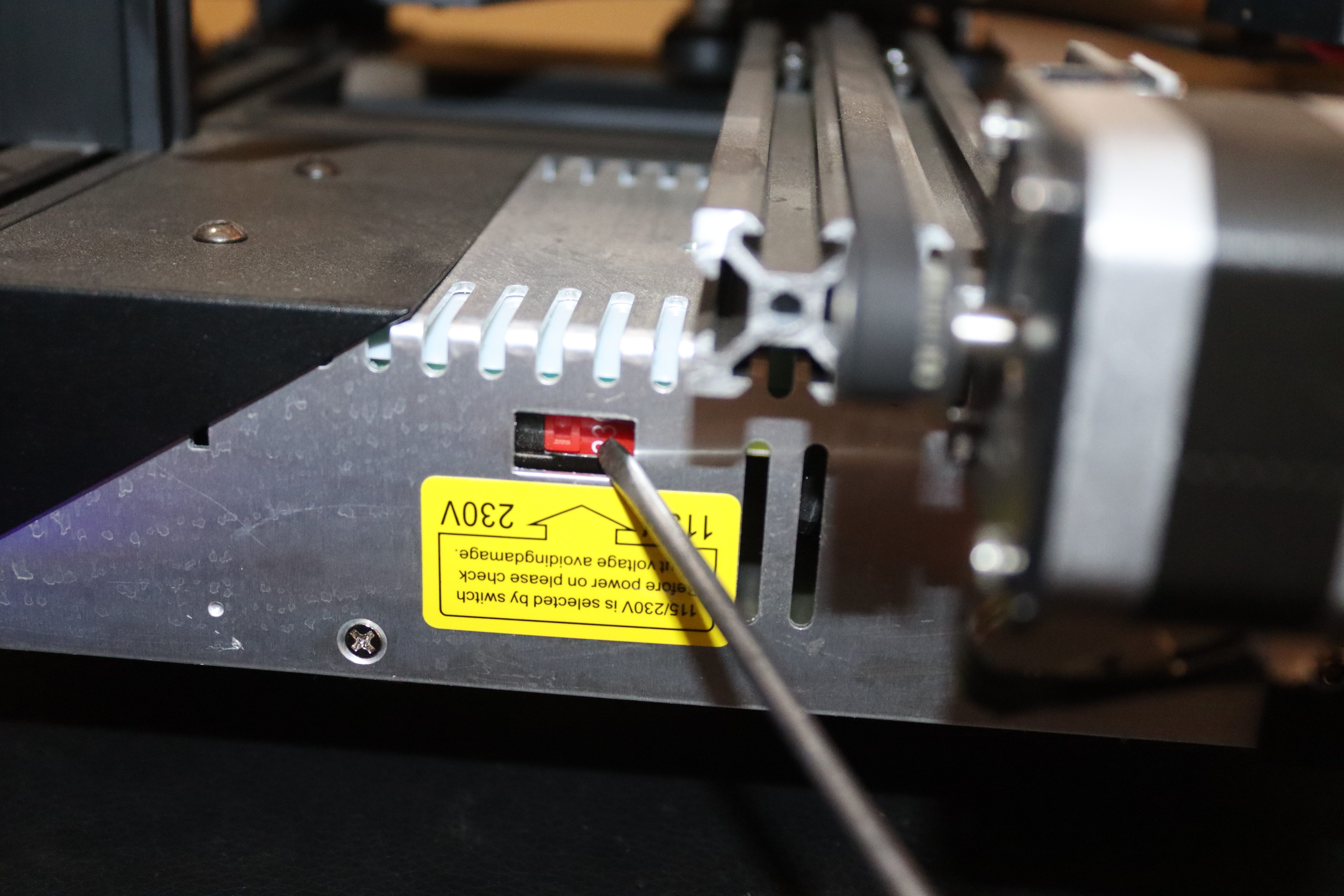 Using a screwdriver to change the voltage of the printer