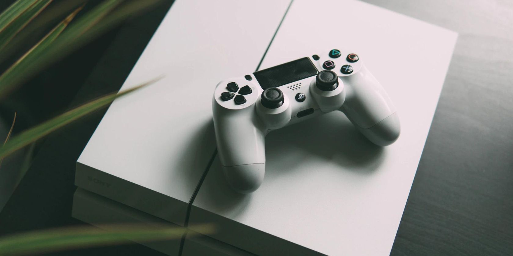 Close up shot of white PS4 with PS4 controller 