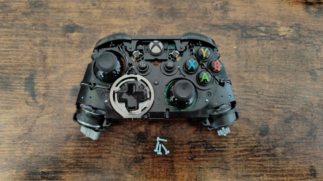 Uma fotografia de um controlador do Xbox One desmontado com as peças internas acessíveis 
