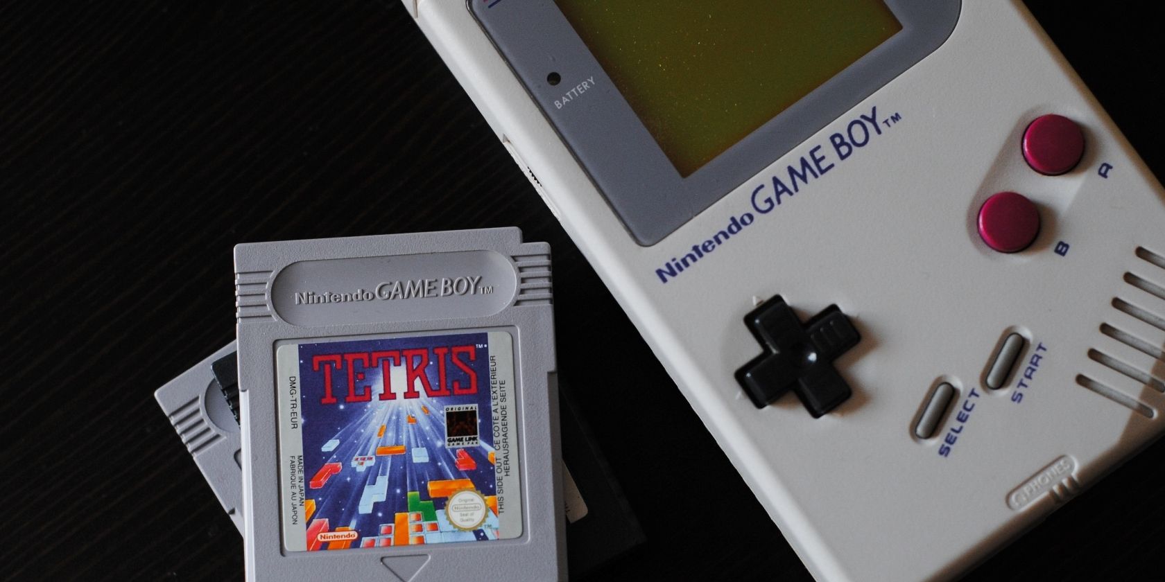 A photograph of an original Game Boy console next to a cartridge for Tetris 