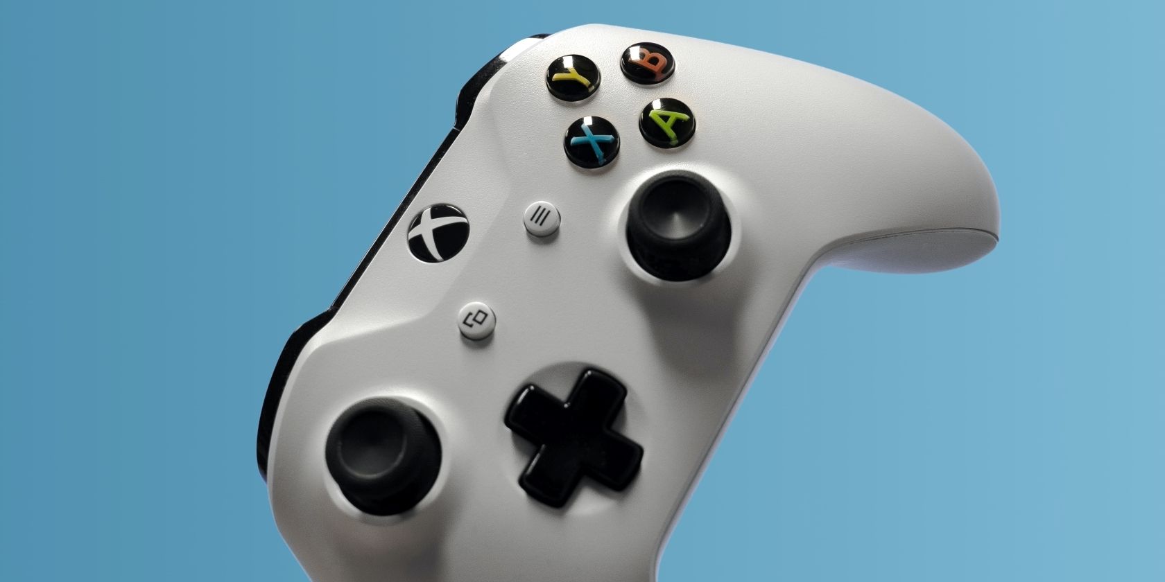 A photograph of a white Xbox One controller against a blue background 