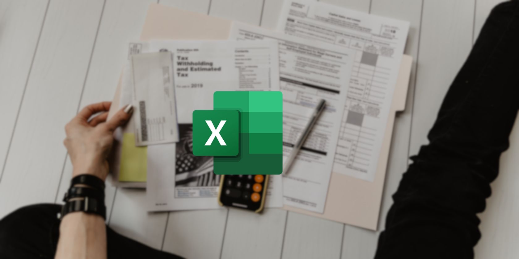 A person seated on the floor leafing through various tax paperwork with the Excel logo superimposed overtop of them.