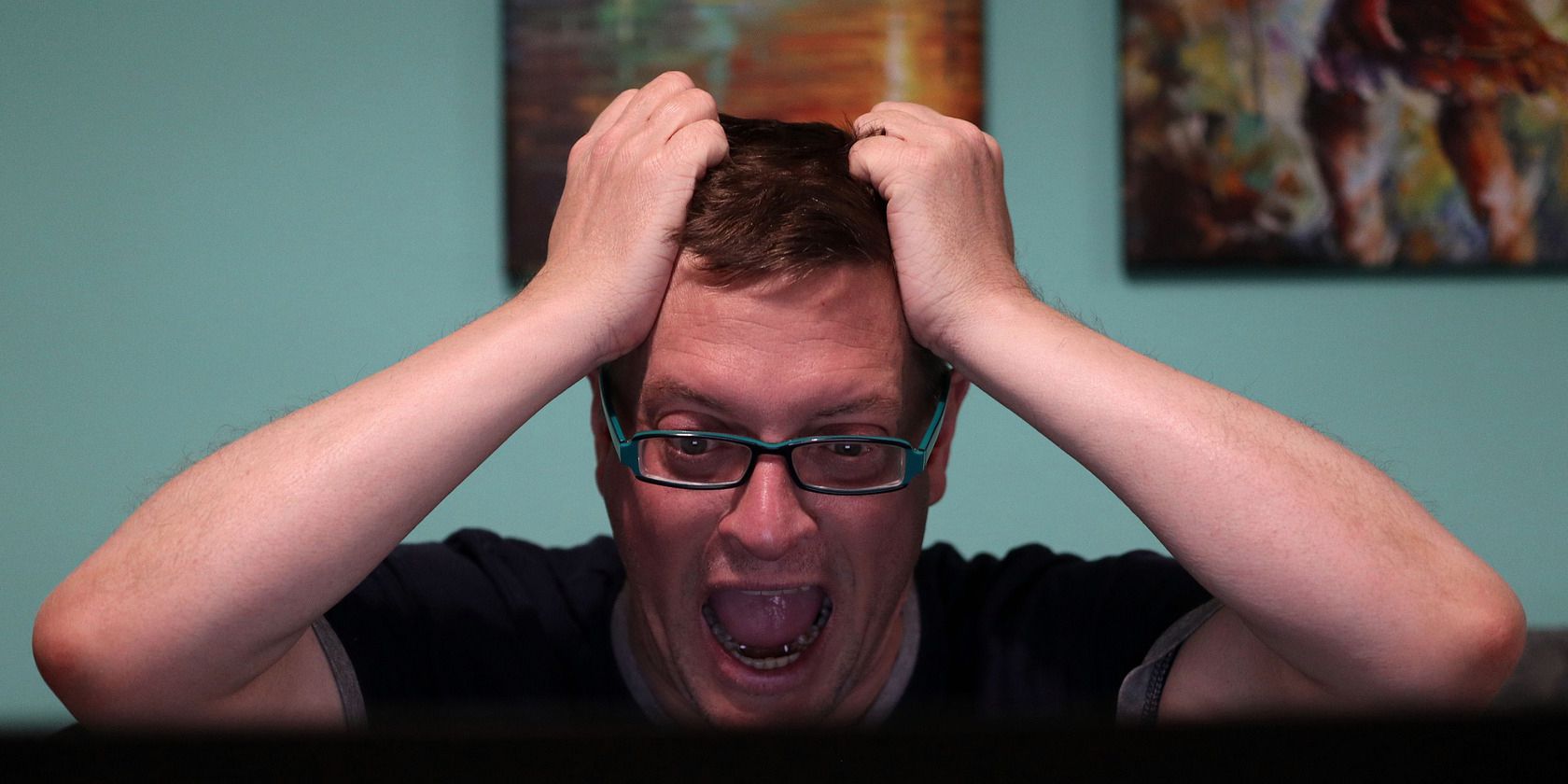 Homem olhando horrorizado para uma tela de computador