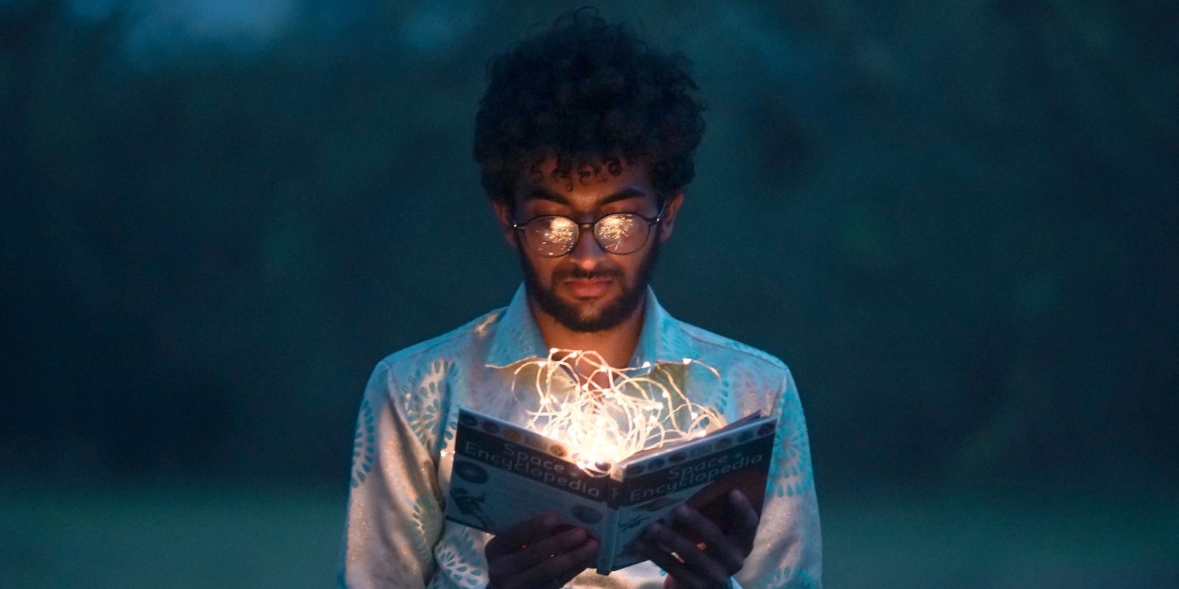 man reading a glowing book