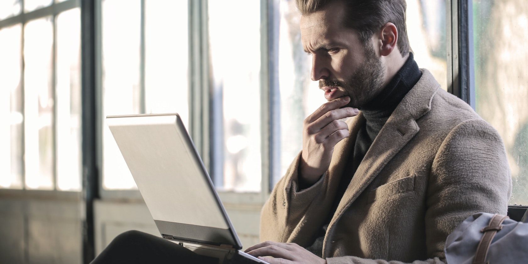 Man with laptop looking pensive