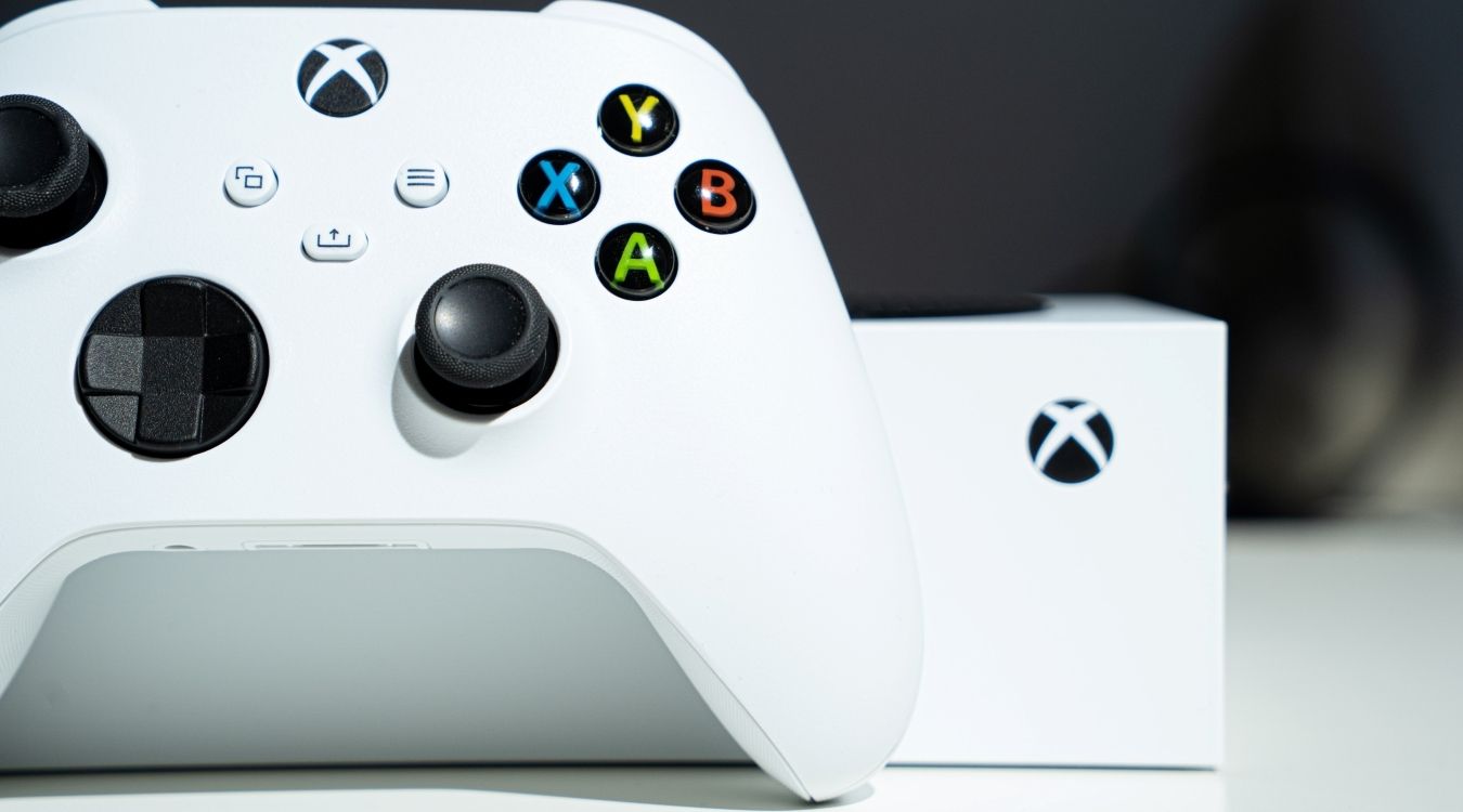 Photo of a white Xbox Series S controller in front of a white Series S console.