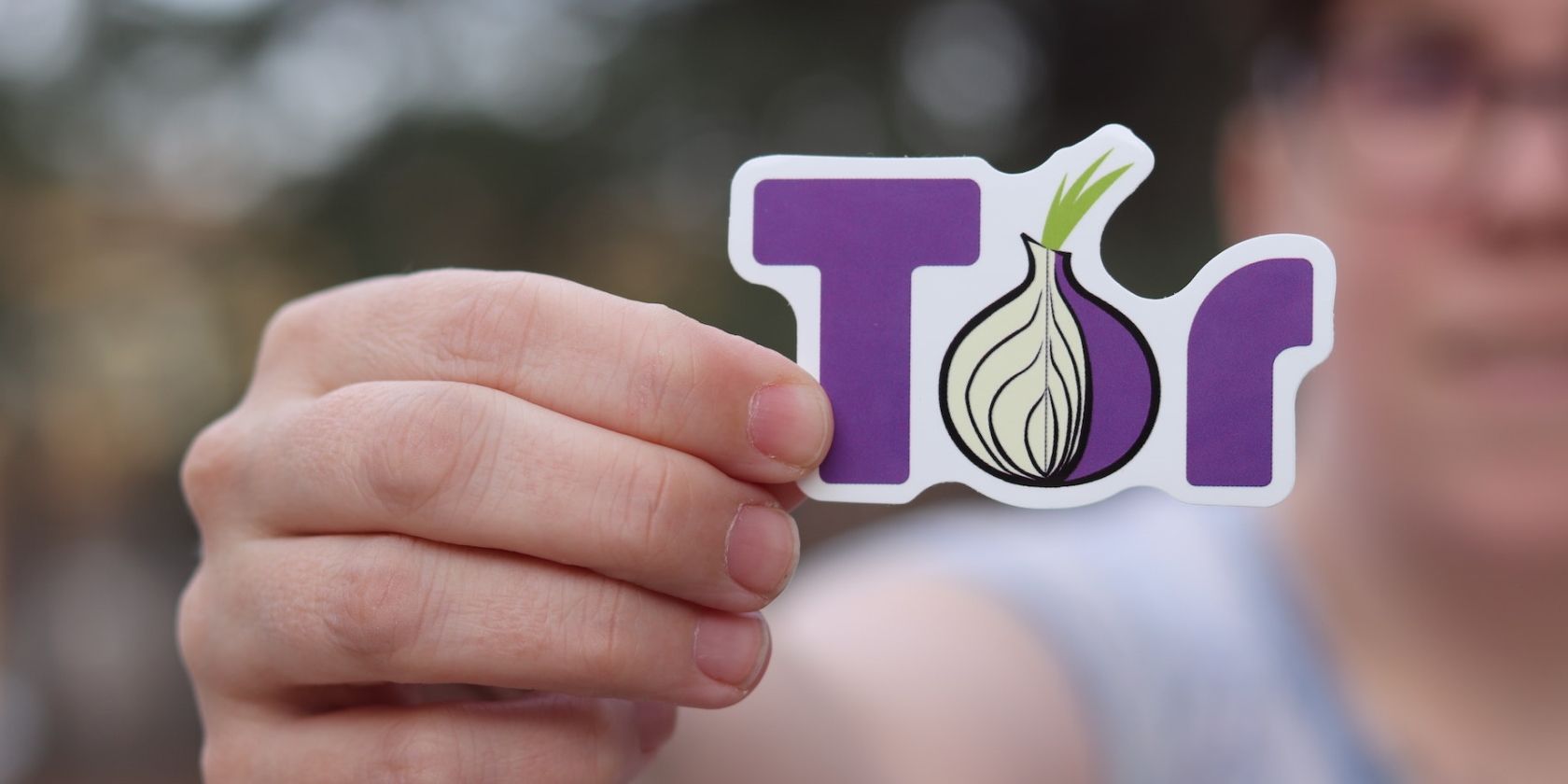 person holding a sticker of Tor