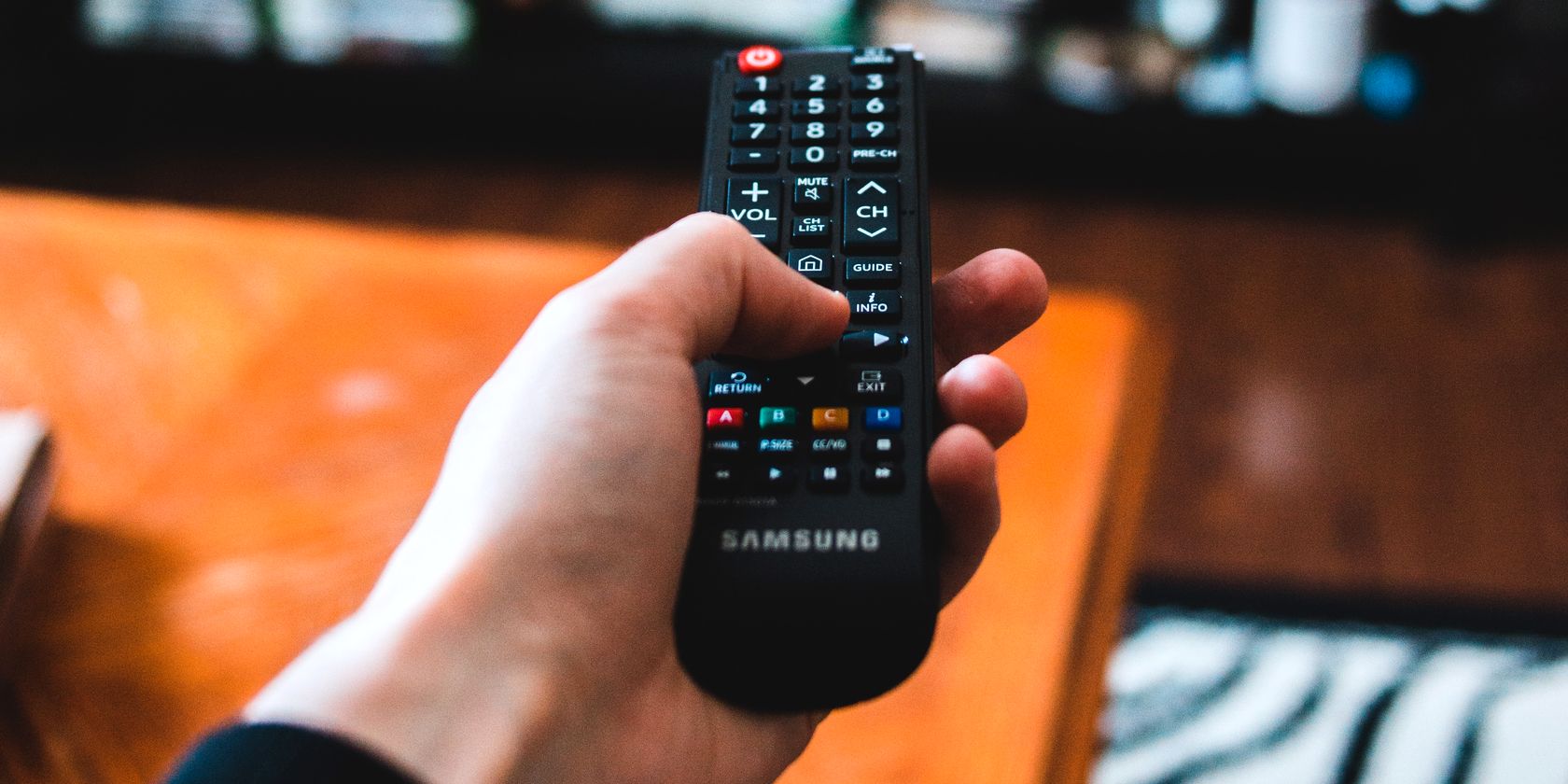 person using remote control to change tv channel feature