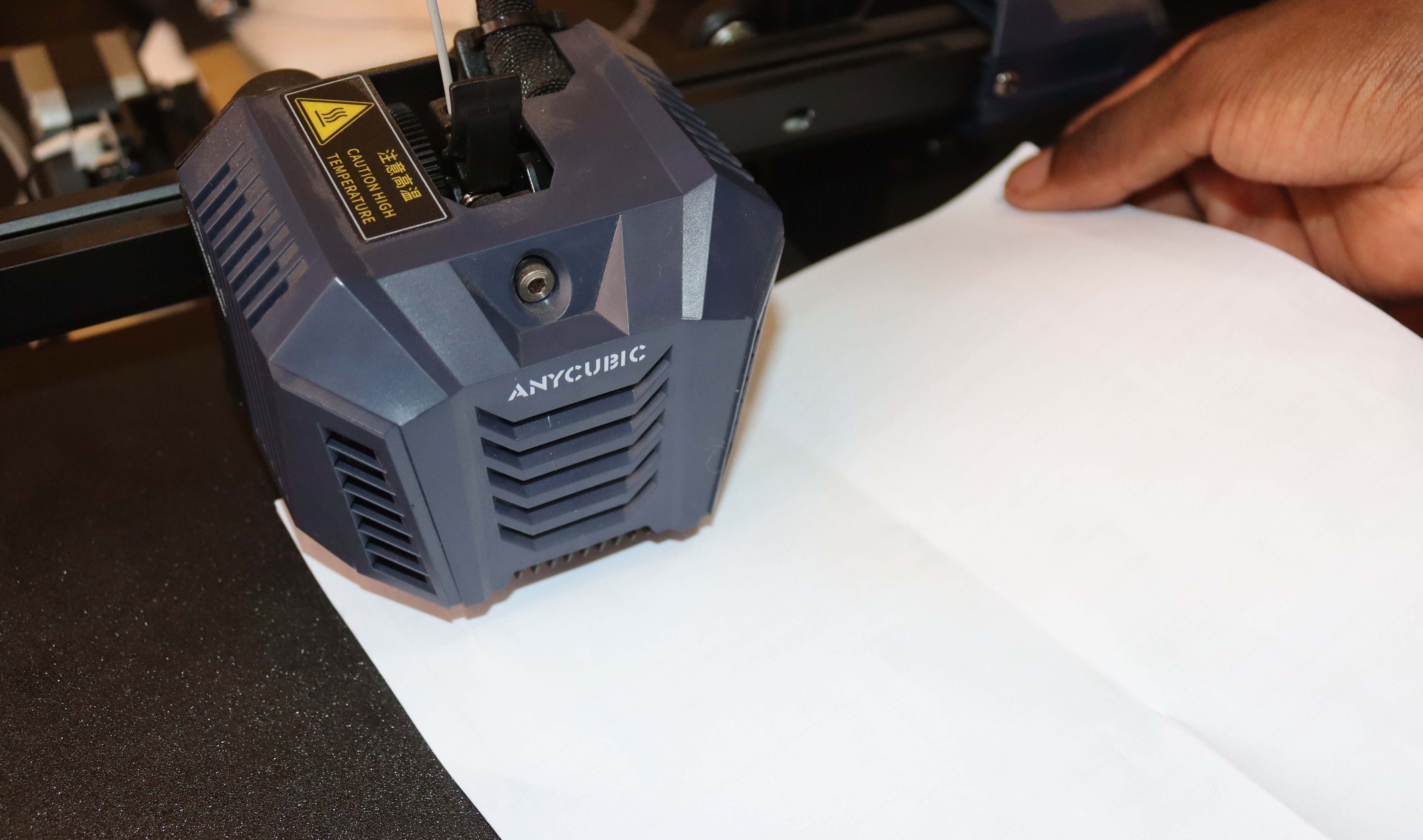 A white paper being inserted below the print head and on the 3D printer bed