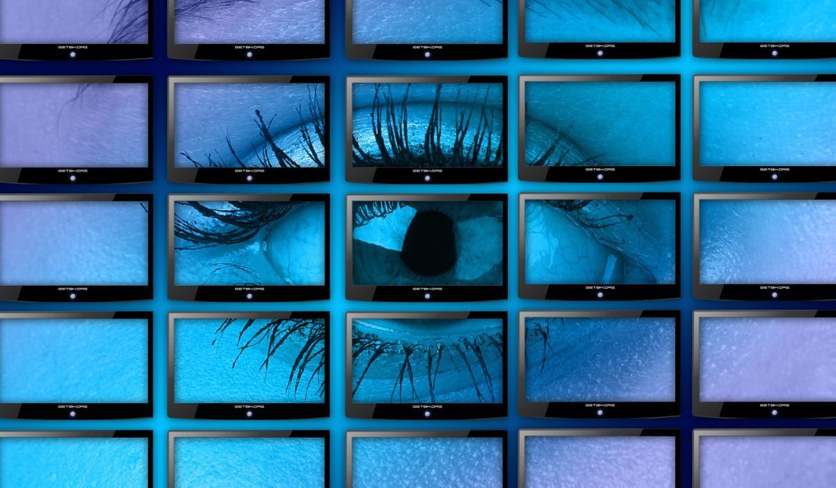 An eye is seen on multiple monitors 