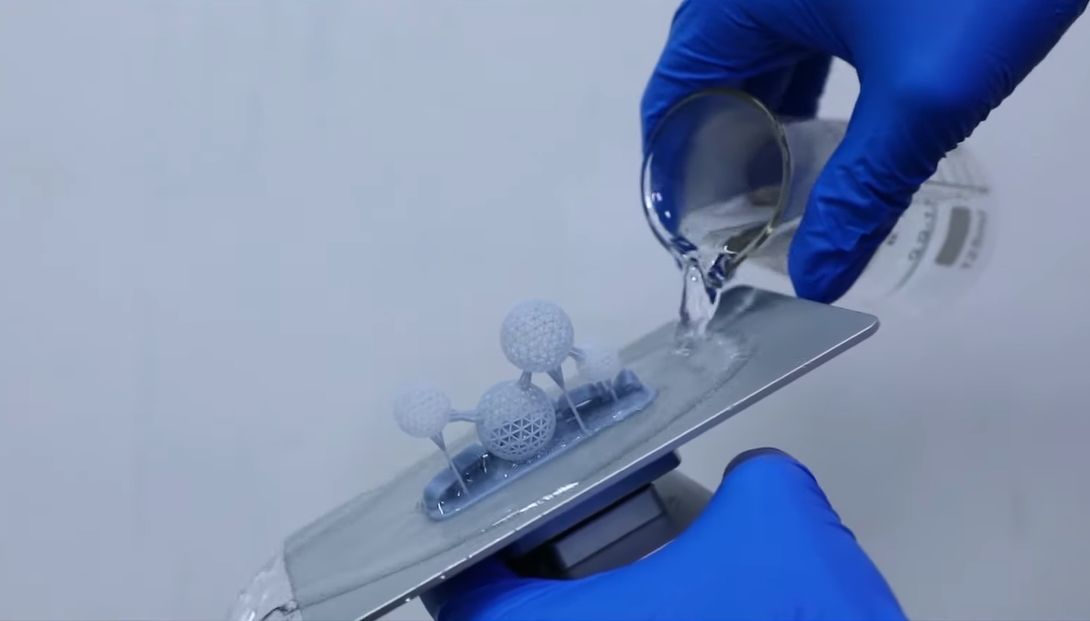 Water being poured on a 3D print to make it easier to remove