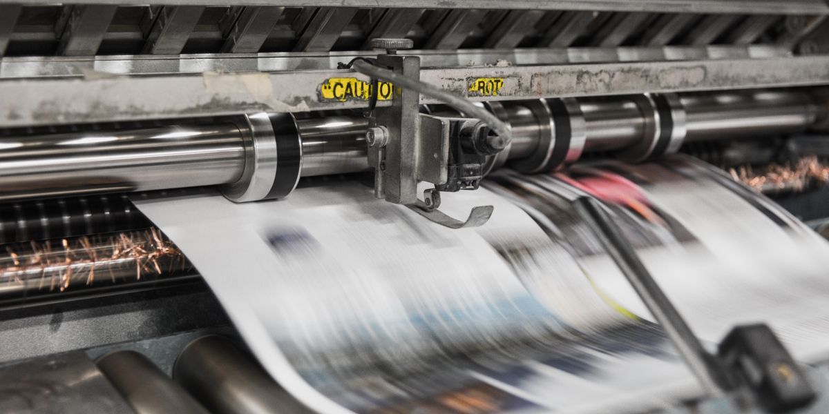 An industrial style printer printing a document out.