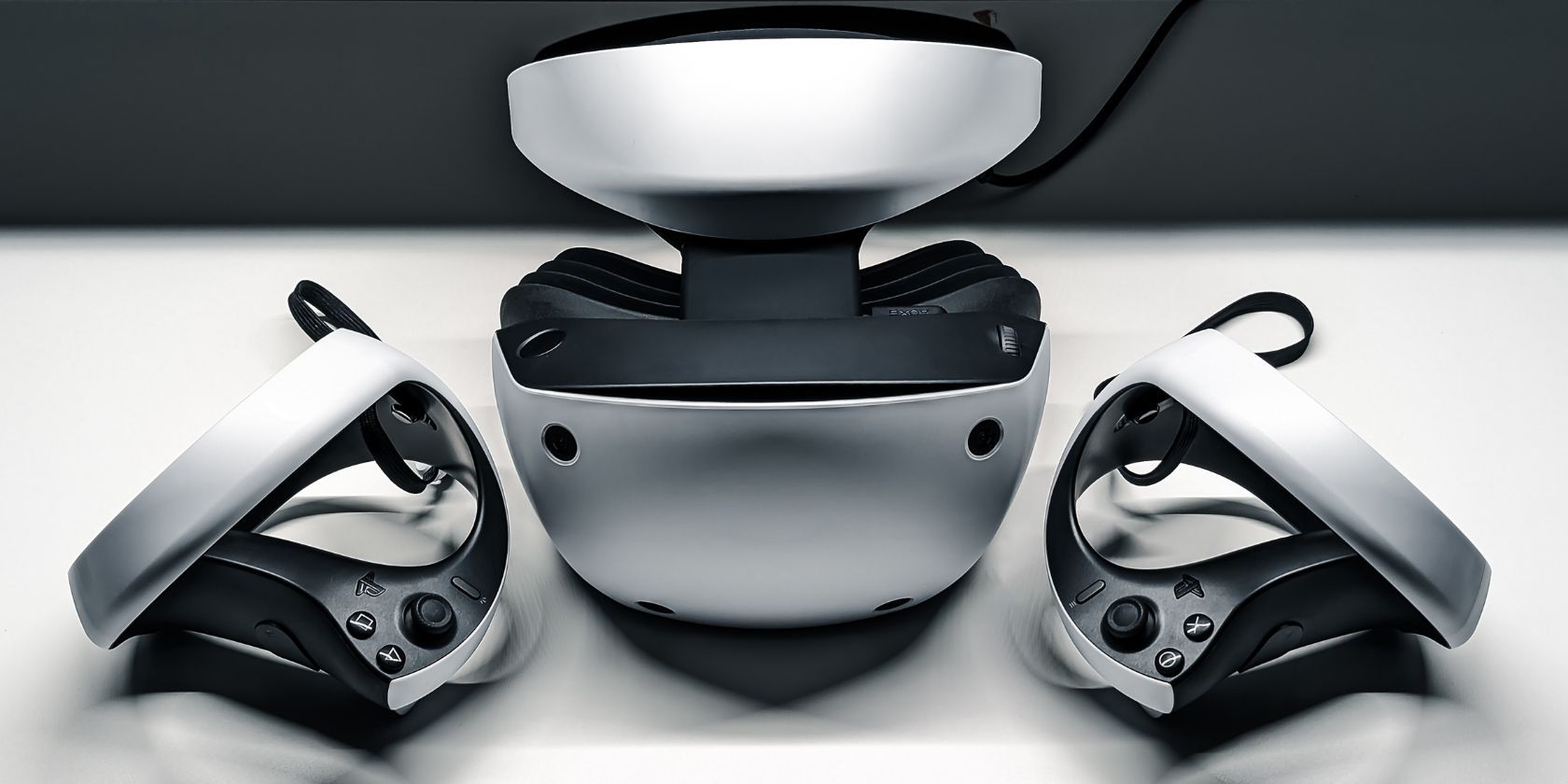 Tai nghe PS VR2 và bộ điều khiển ngồi trên bàn trắng