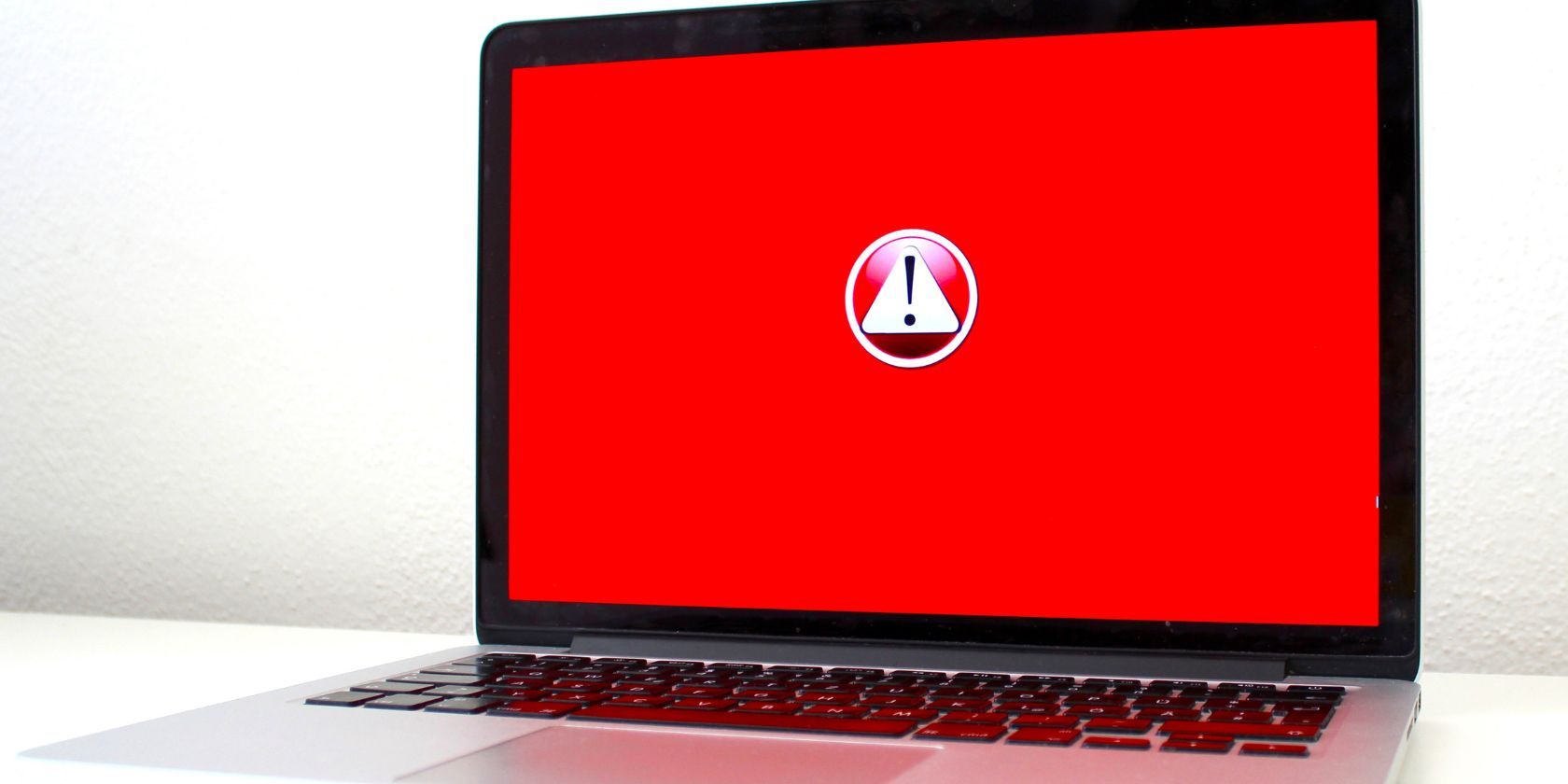 máy tính xách tay với biểu tượng cảnh báo màu đỏ trên màn hình