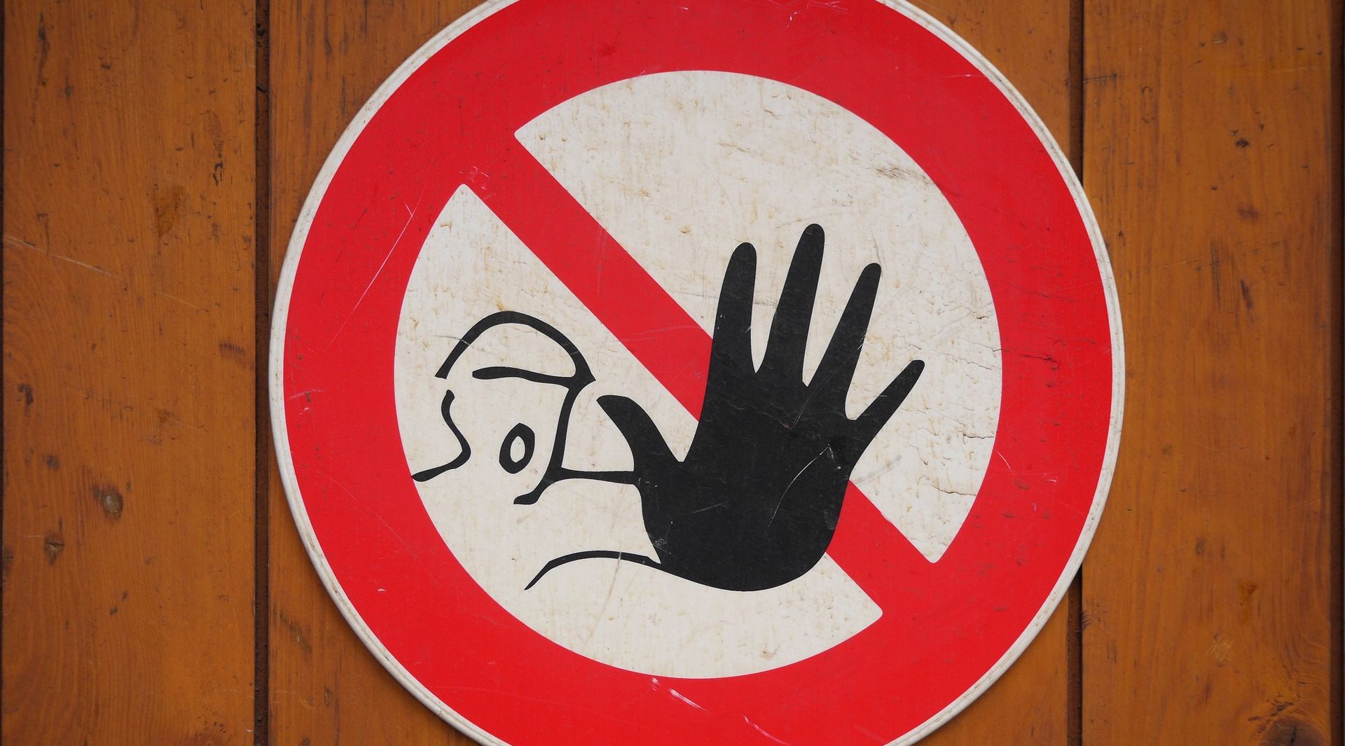 red warning sign of person putting up hand