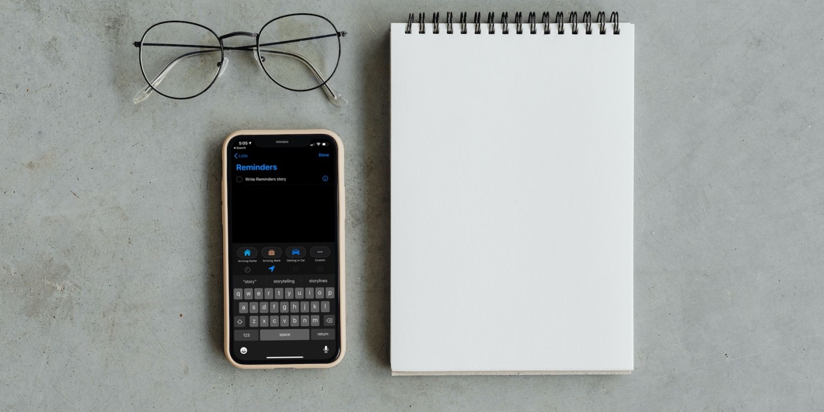Reminders app on an iPhone next to a notepad