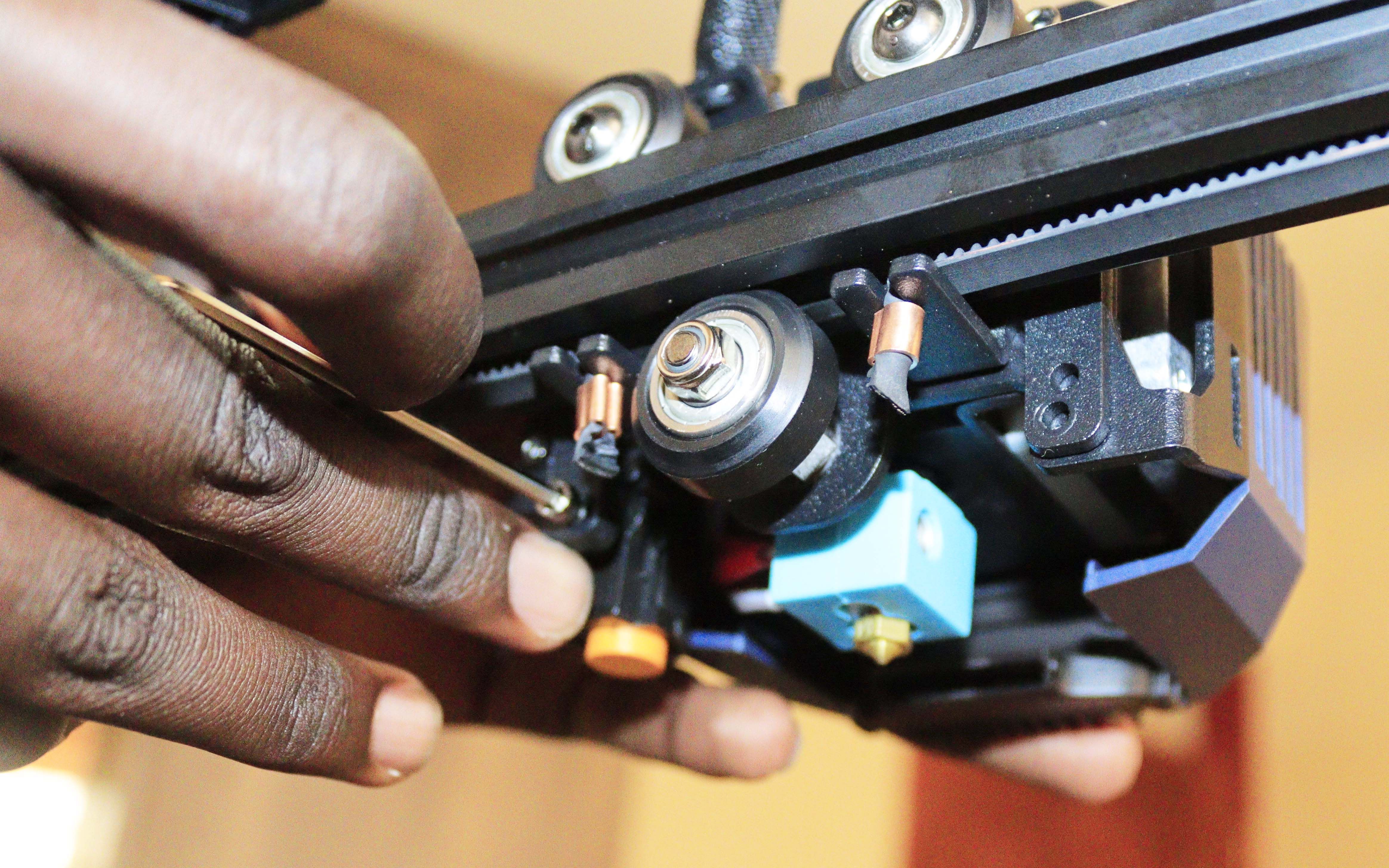 Using a wrench to tighten the screws on the print head