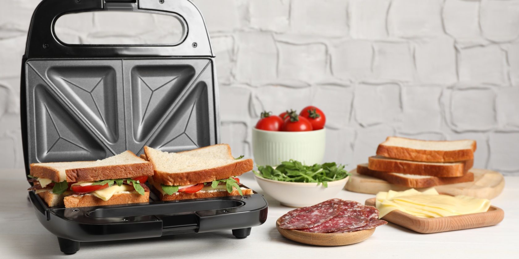sandwich maker with sandwich inside and a selection of ingredients