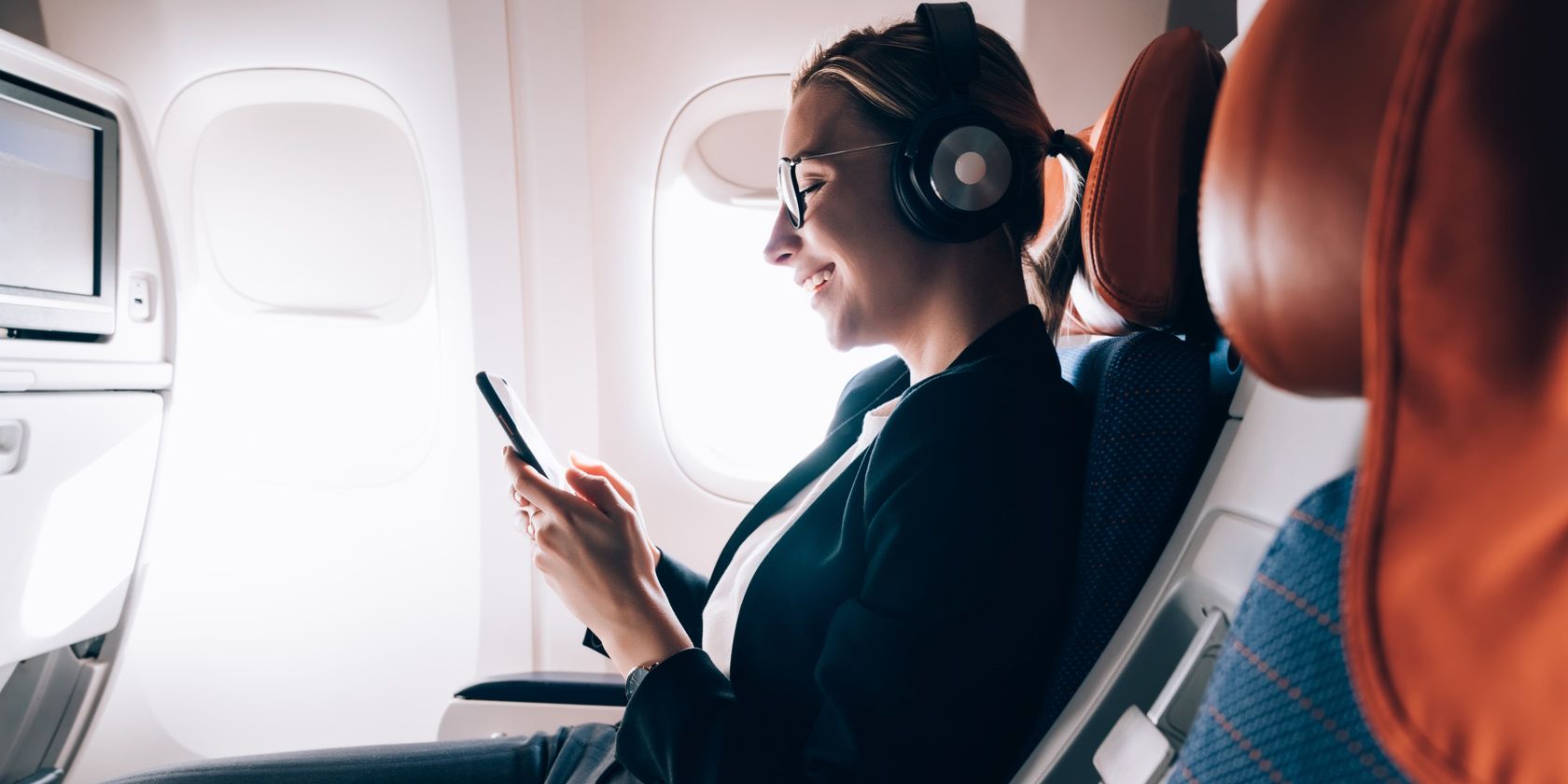 photo of a woman listening to music on a plane