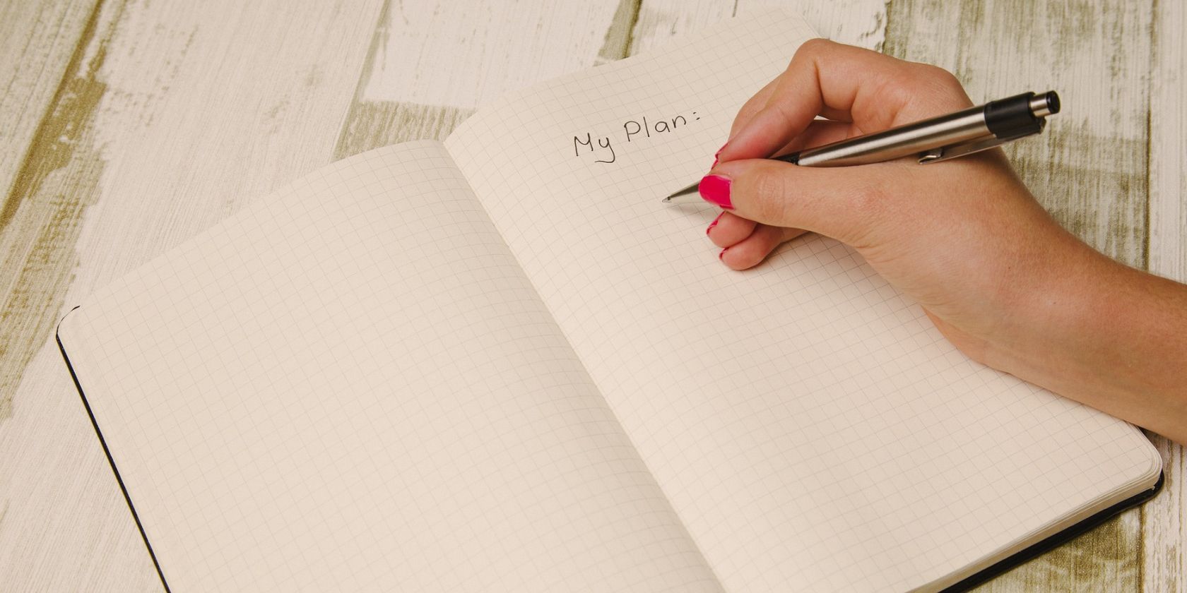 A hand writing a plan in a diary