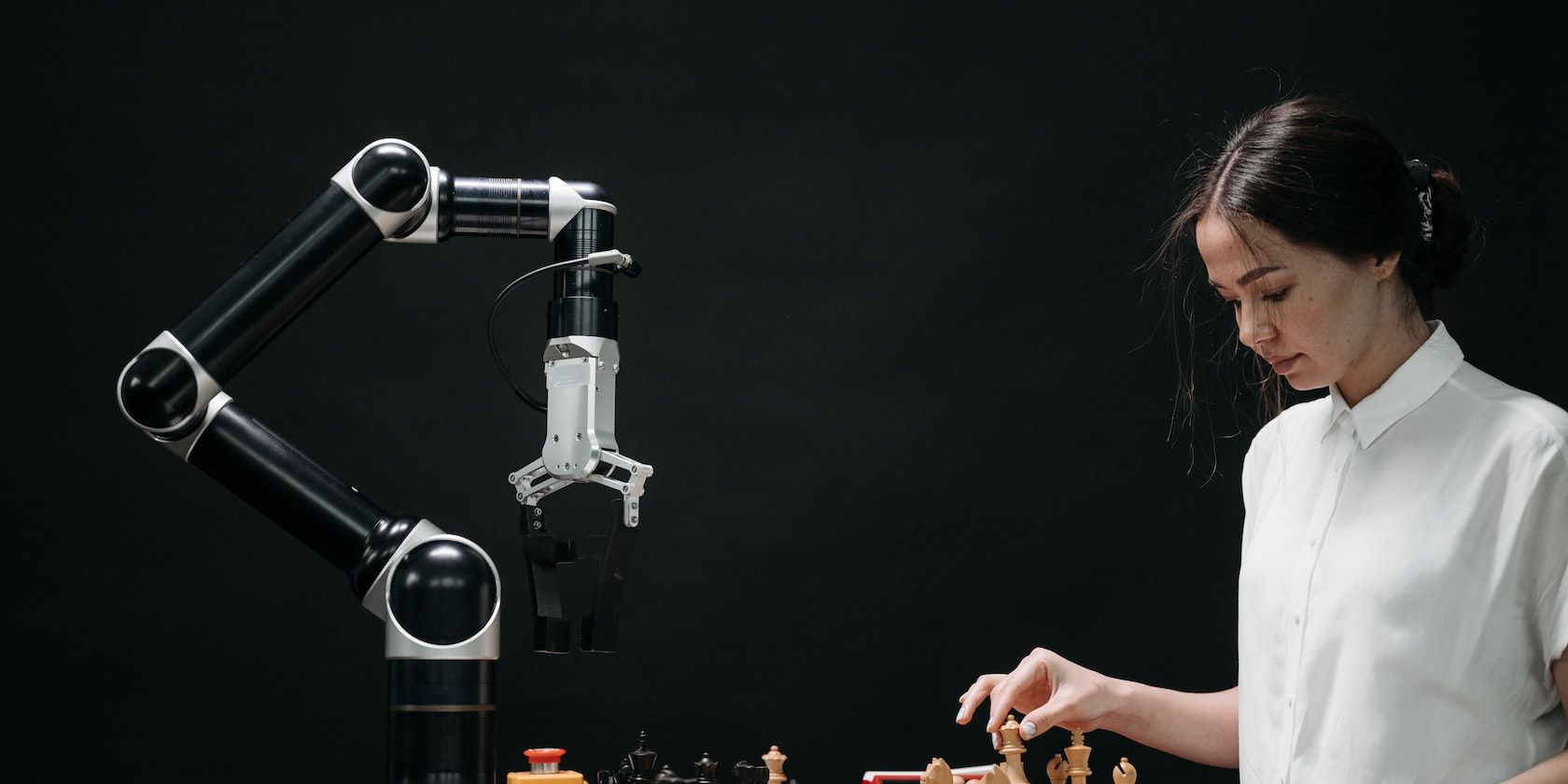 Femme en chemise blanche jouant aux échecs contre un robot
